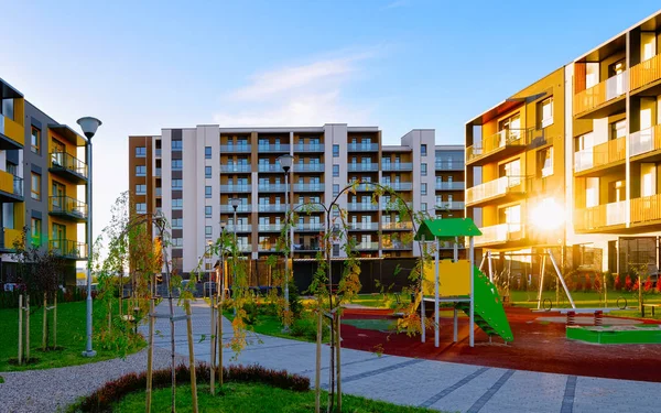 Apartamento casa residencial fachada arquitectura con niños parque infantil sol reflejo de luz — Foto de Stock
