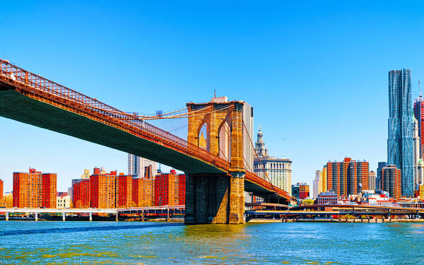 Brooklyn bridge across East River, New York, USA. It is among the oldest in the United States of America. NYC, US. Skyline and cityscape. American construction