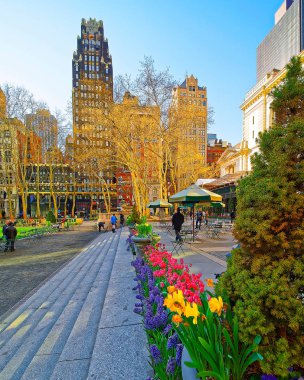 Çiçek açan yeşil bitkiler ve Bryant Park refleksindeki gökdelenler