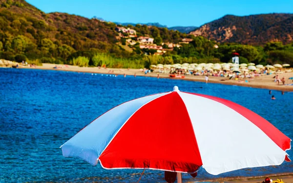 Guarda-chuva na praia de Chia no Mar Mediterrâneo reflexo — Fotografia de Stock