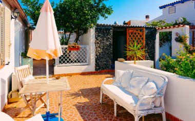 Costa Smeralda refleksindeki sundurmada masa ve kanepe.