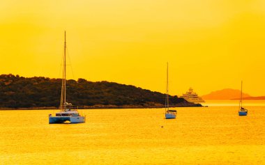 Porto Rotondo refleksinde yatlarla gün doğumu veya gün batımı