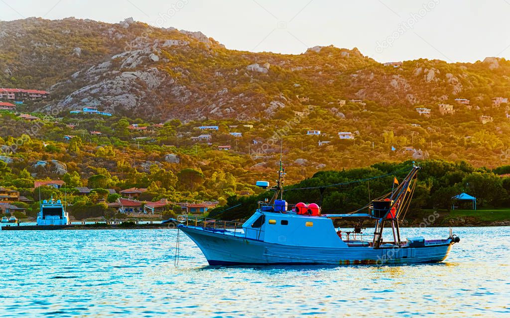 Sunrise with boat Costa Smeralda at Mediterranean sea Sardinia reflex