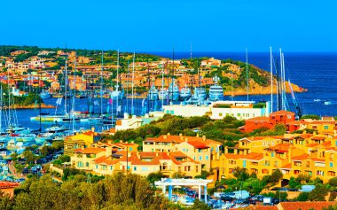 Porto Cervo İtalya refleksi marinasında lüks yatları olan şehir manzarası.