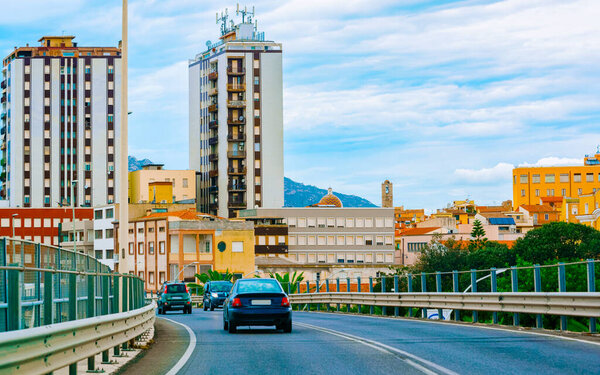 Cars on summer road in Olbia city on Sardinia reflex