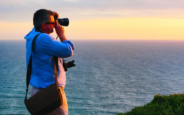 Homem tirando fotos do pôr do sol em Portoscuso Carbonia Sardenha reflexo — Fotografia de Stock