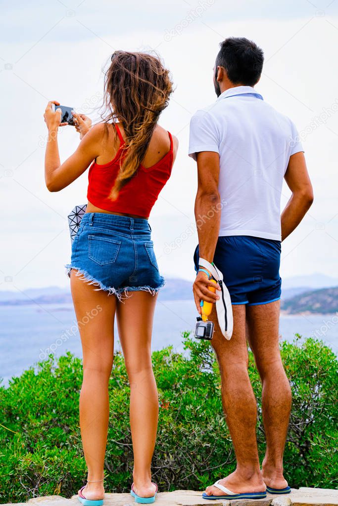 Young Couple taking photos of Tavolara Island reflex