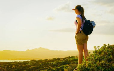 Costa Smeralda tatil beldesinde gün doğumuna bakan genç kız Akdeniz refleksi