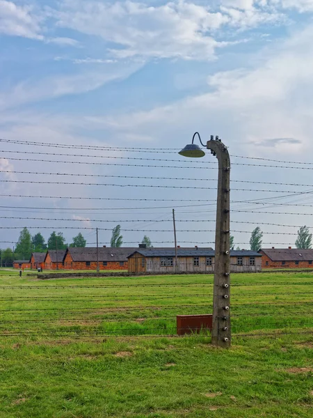 Budovy kasáren a ostnatý drát v koncentračním táboře Osvětim Birkenau — Stock fotografie