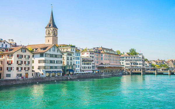 Zurich city center and Limmat quay in summer with Cathedral and city hall clock towers spires in summertime. Mixed media.