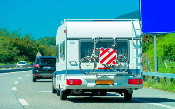 Караван с велосипедом на шоссе в Швейцарии
