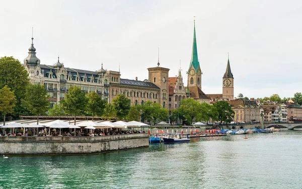 Restaurant terrace at Limmat quay and Saint Peter Fraumunster — Stock Photo, Image