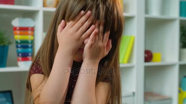 Schattig klein meisje sluit en opent zijn handen over haar gezicht. Kinderen kamer achtergrond. Close-up — Stockvideo