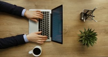 İşadamı laptop ile çalışma ve Ofis Masası üzerinde kahve içme eller. Üstten Görünüm. ağır çekim