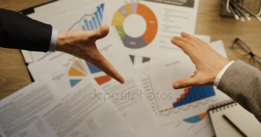 Üstten Görünüm, Ofis Büro finansal arka plan ile el sıkışan iki iş adamlarından. Eller en iyi görünümü. Ağır çekim. El sıkışma