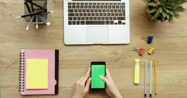 Eller en iyi görünümü. Onun smartphone ile yeşil ekran kullanarak, haber kaydırma, fotoğraflar üzerinde dokunarak kadın. Ofis Resepsiyon arka plan. Ağır çekim. Kırmızı epik