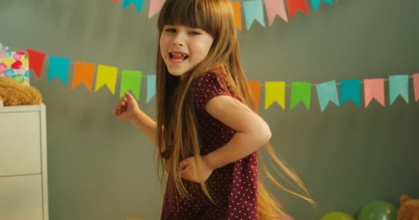 귀여운 어린 소녀 생일 파티에서 슬로우 모션에 춤을. 집에서 춤 재미 작은 소녀. 클로즈업 — 비디오