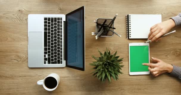 Vista superior de las manos del hombre que trabajan con el ordenador portátil y las manos de la mujer que trabajan con la tableta en el escritorio de oficina. Negocios. En cámara lenta. épica roja. Pantalla verde — Vídeo de stock