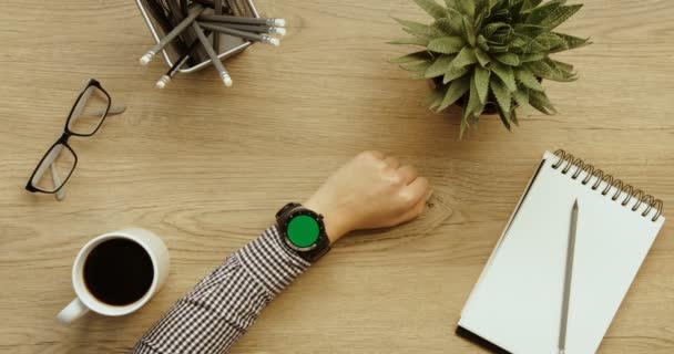 Mujer de negocios usando su reloj inteligente con pantalla verde. Desplazamiento y tocando imágenes. Manos femeninas vista superior. Fondo de escritorio de oficina. En cámara lenta. épica roja. Empresaria — Vídeo de stock