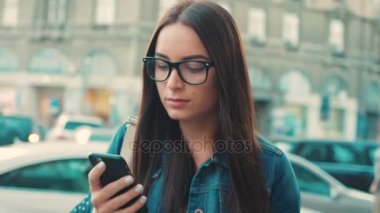 Akıllı telefonda App kullanarak ve şehir sokakta yürürken etrafa güzel kadın. Yakın çekim