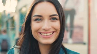 Kadın portre sokak şehir dışında kapatın. Kameraya bakarak ve gülümseyen çekici kadın.