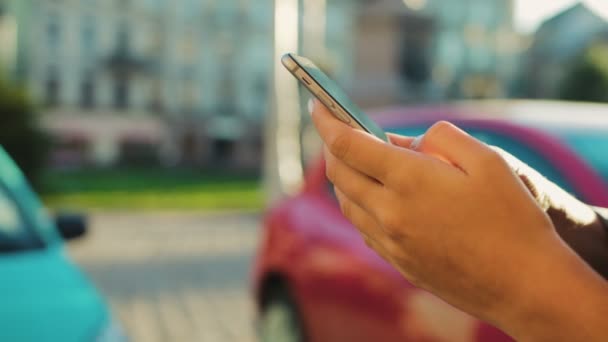 Cerca de las manos de la mujer usando el teléfono inteligente en el patio de la calle de la ciudad. Tocar a mano en la pantalla táctil — Vídeos de Stock