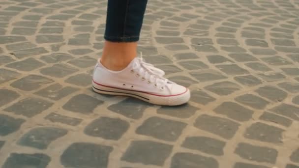 Arnavut kaldırımlı sokakta yürüyen kadın. Kadın bacaklar beyaz ayakkabı kapatın. Yan görünüm — Stok video