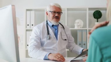 Hasta bir şeyler açıklamaya beyaz orta yaşlı Doktor Röntgen görüntü, seyir sakallı bardaklarda. Kapalı.