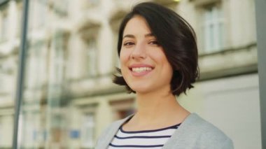 Çekici genç kadın şehrin sokak kameraya gülümseyen yüz portresi. Büyük pencere arka plan. Yakın çekim