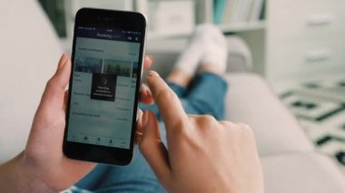 New York - 10 Şubat 2017: rezervasyon com kullanarak kadın eller daire seçimi ve ilginç için akıllı telefon app gelecekteki yolculukta yerleştirir. Yakın çekim.