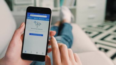 New York - 10 Şubat 2017: kadın el kanepede yatan apartments gezi için arama için akıllı telefon fouresquare app kullanarak. Yakın çekim.