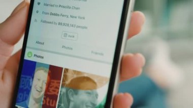 New York - 10 Şubat 2017: kadın kanepede yatan ise Facebook beslemeleri akıllı telefon üzerinde tarama. Atış kapatın.