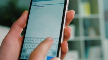 New York - 10 Şubat 2017: kadın el kot online mağazasında Koç evde oturma odasında yatan süre araştırıcı için akıllı telefonu için kullanma. Yakın çekim.