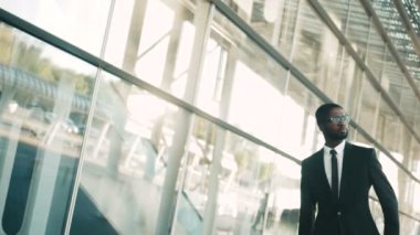 Büyük ofis Merkezi windows yürüme çekici Afrikalı-Amerikalı iş adamı. Açık havada. Ağır çekim