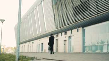 Siyah Afrika kökenli Amerikalı iş adamı ofis Merkezi büyük pencereler bina boyunca yürüyüş.