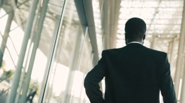 Büyük ofis windows açık havada yürüyüş emin Afrikalı-Amerikalı iş adamı. Arkadan Görünüm. Arkadan vurdu. Yakın çekim