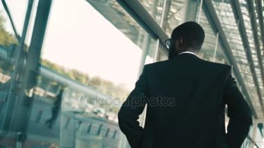 Büyük ofis windows açık havada yürüyüş emin Afrikalı-Amerikalı iş adamı. Modern bina. Arkadan Görünüm. Arkadan vurdu. Yakın çekim