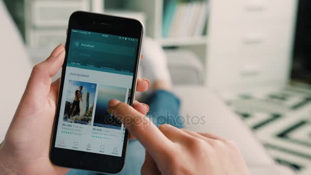 New York - March 10, 2017: Woman hands browsing rooms and hotels to rent on Airbnb app on smart phone. Close up. Indoor shot. — Stock Video