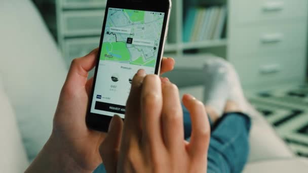 Nova York - 10 de março de 2017: Mulher encomendando um carro de táxi uber usando telefone inteligente enquanto está sentado em casa na sala de estar. Fechar . — Vídeo de Stock