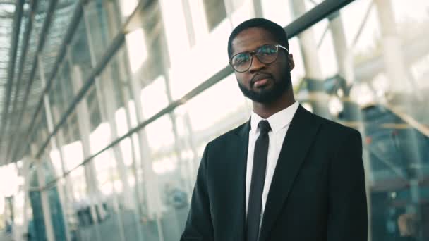 Close up retrato de atraente confiante empresário afro-americano olhando diretamente para a câmera. Ao ar livre perto de janelas de escritório — Vídeo de Stock