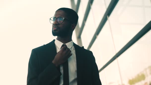 Retrato de hombre de negocios afroamericano atractivo confiado parado al aire libre cerca de las ventanas bulding del centro de la oficina. De cerca. — Vídeos de Stock
