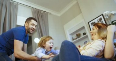 Mutlu bir aile evde birlikte vakit. Babası kızı anne holding oğul diz ile oynuyor. Annesi, babası, oğlu, kızı. Aile gülüyor