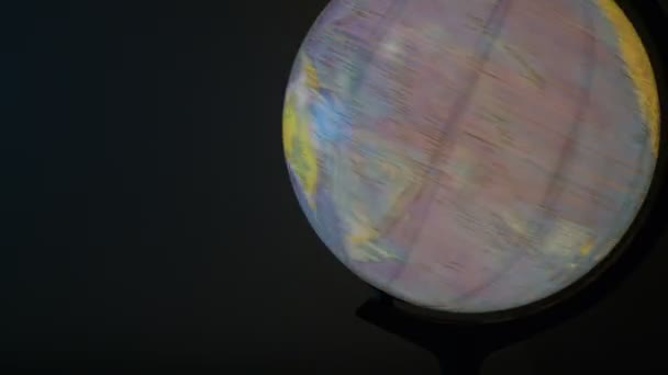 Nahaufnahme des Globus mit Hintergrundbeleuchtung auf schwarzem Hintergrund. Lichtkugel, die sich im Dunkeln dreht. Globalkarte — Stockvideo