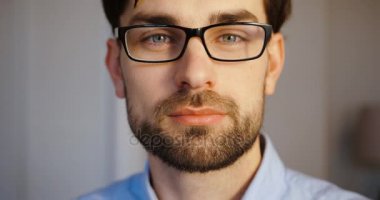 Çekici bir genç adam portresi. Genç iş adamı possing ang smilinhg fotoğraf makinesinde. Ağır çekim. Yakın çekim.