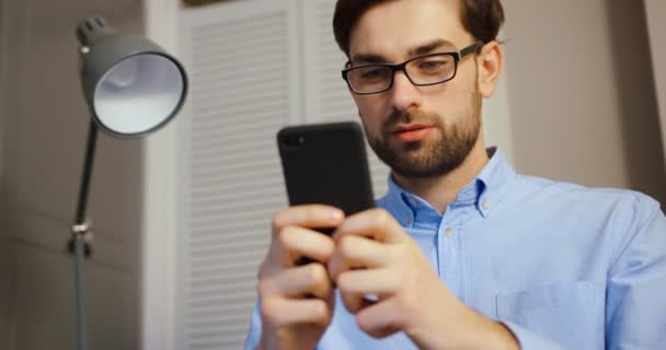 Attraktiv man skriva meddelande på smart telefon. Verksamhet man arbetar på sin mobiltelefon. Närbild. — Stockvideo