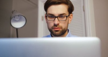 Onun dizüstü bilgisayarda yazarak güzel adam. Office arka planda çalışan iş adam. Yakın çekim.