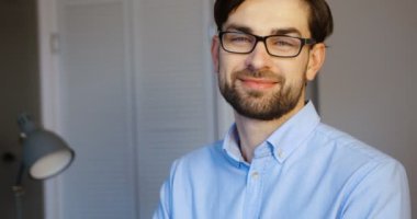 Kamera çekici bir genç adam possing. Office arka plan üzerinde gülümseyen iş adamı. Yakın çekim.