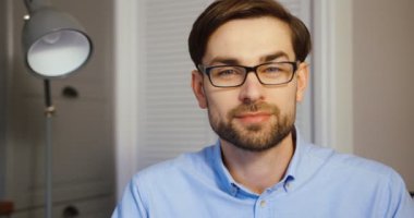 Kamera çekici bir adam possing. Office arka plan üzerinde gülümseyen iş adamı. Yakın çekim. Ağır çekim.