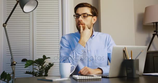 Negocios jóvenes pensando en la oficina. Hombre atractivo crear la gran idea y escribir a la computadora portátil . — Vídeos de Stock