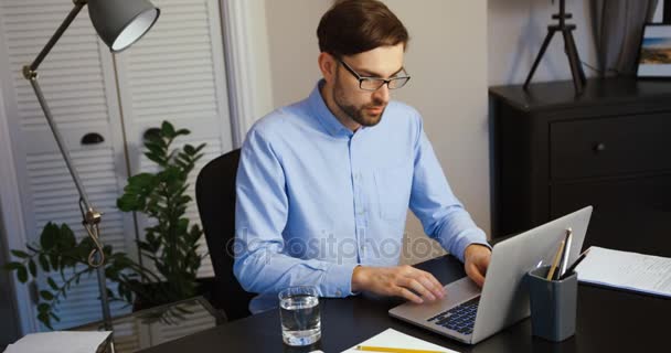 Tânărul lucrează la laptopul din birou. Omul de afaceri tastează pe laptop. Birou fundal . — Videoclip de stoc